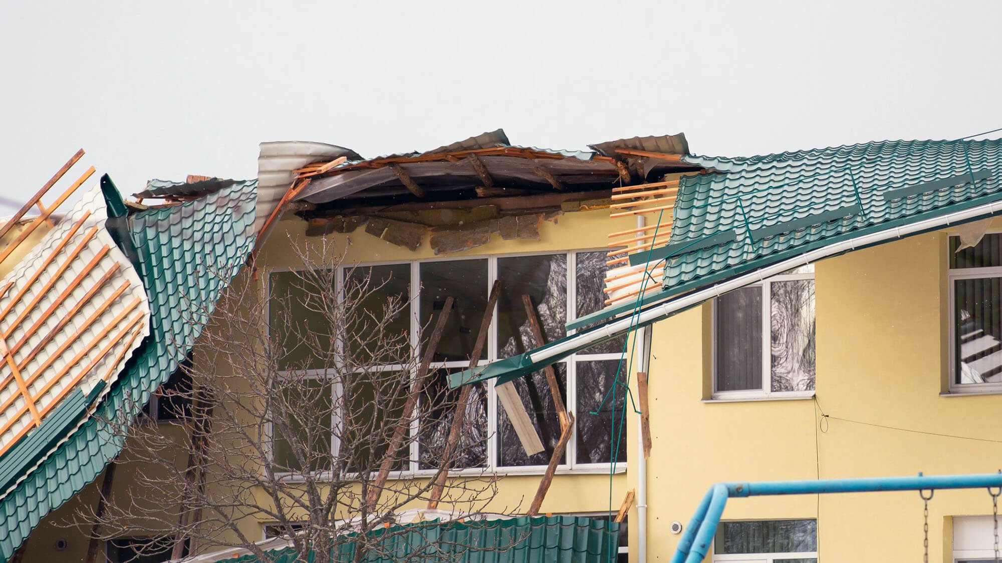 Damaged roof of a building. Strong wind, tornado, storm concept