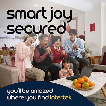 A family smiling and gesturing with clasped hands while seated in front of a laptop