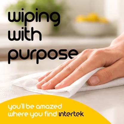 A hand wiping down a counter with a piece of white cloth